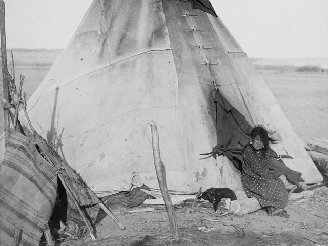 Eine Indianerin betritt ein Tipi.